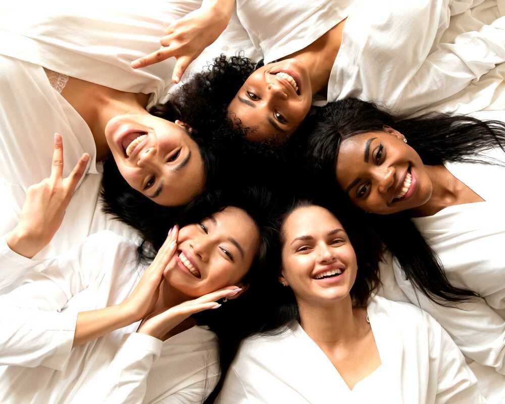 Chilled Bachelorette Party Ideas - Women lying in a circle in pamper robes, smiling